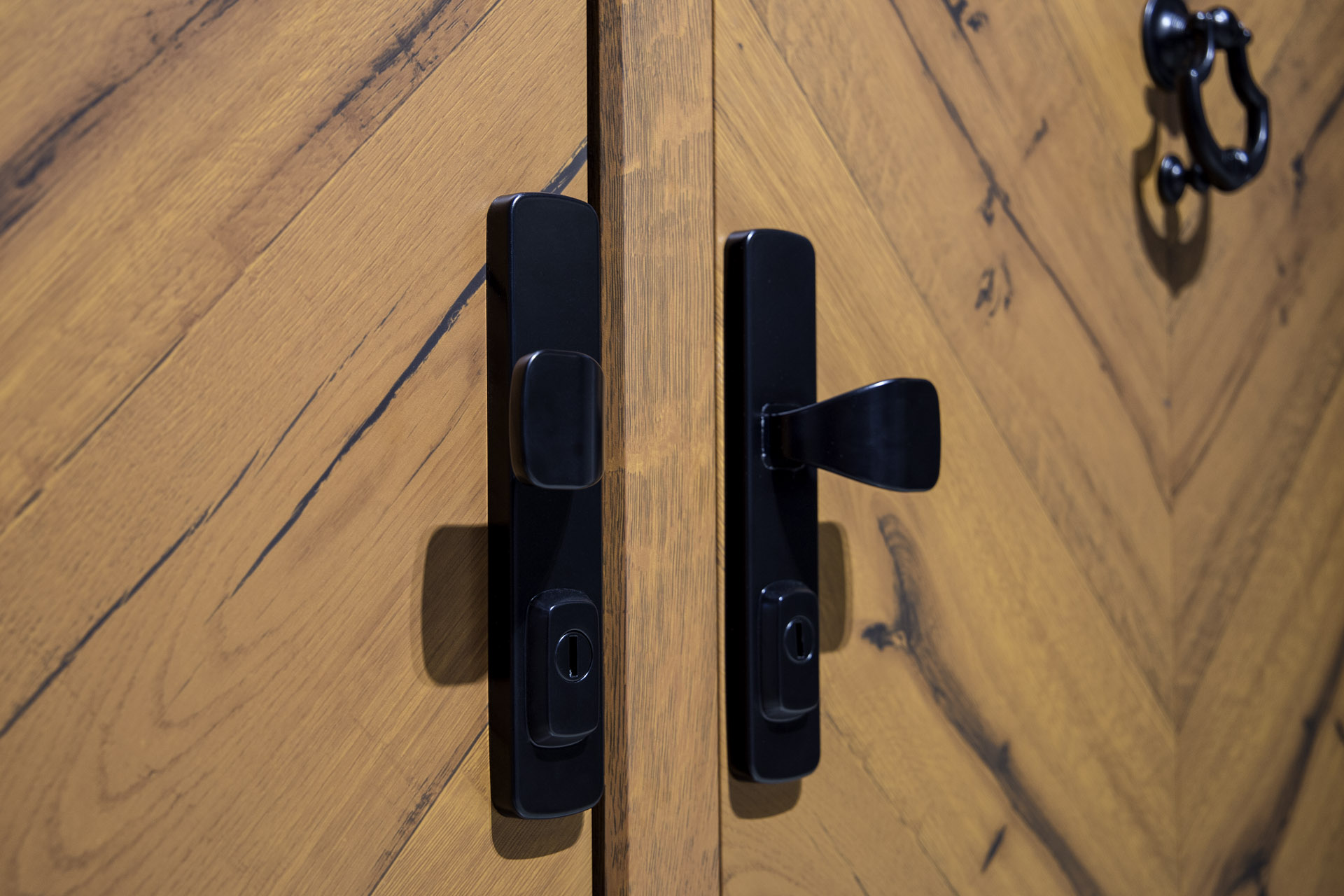 Maniglia nera tradizionale su porta d’ingresso effetto legno