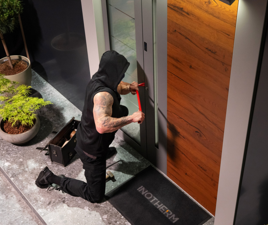 Scassinatore che tenta di forzare una porta d’ingresso